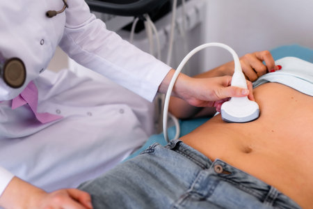 Ultrasound sensor of modern ultrasonic scanner in young woman doctor's hands preparing for a device...