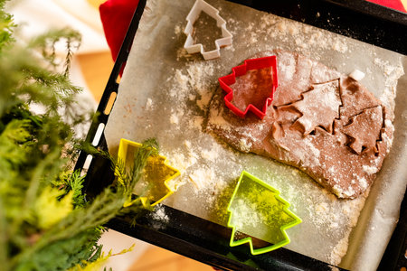 Detailed shot of gingerbread cookies dough and plastic cookies cutter on wooden worktopの写真素材