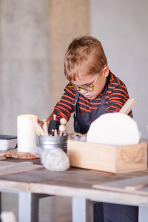5-Year-Old Boy with Glasses Exploring Handmade Ceramics.