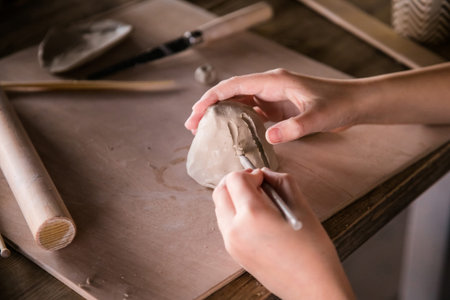 Handmade Clay Art: Close-Up of Children's Hands in Ceramics.