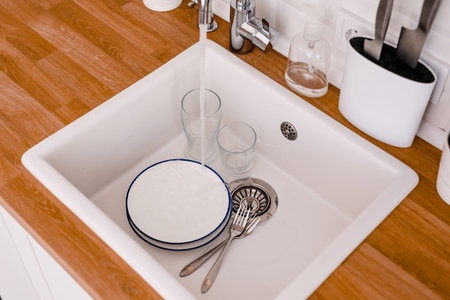 Clean white sink on wooden table in white kitchen.