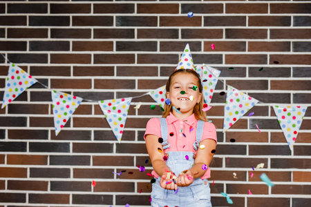Cute preschooler girl makes art at a summer outdoor party.