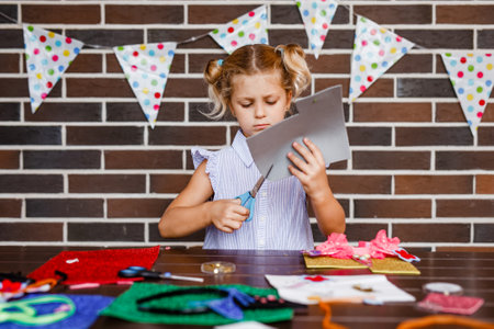 Blonde preschooler girl makes art at a summer outdoor party.の写真素材