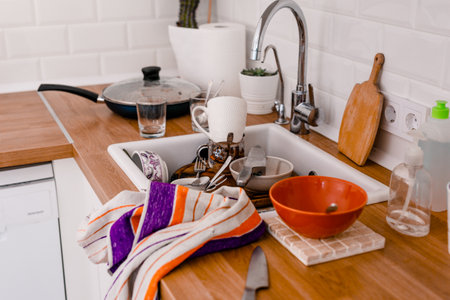 Clutter, dirty dishes by the sink in the white kitchen.の写真素材