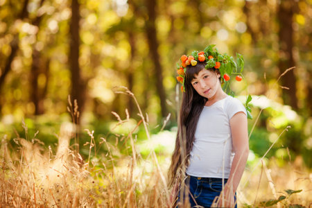 Portrait of little girl in autumn park with yellow foliageの写真素材