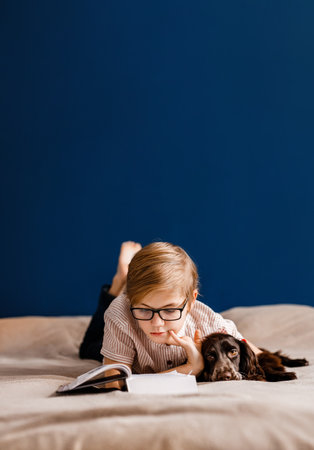 boy wearing glasses reading a book, book lover concept, learn to readの写真素材