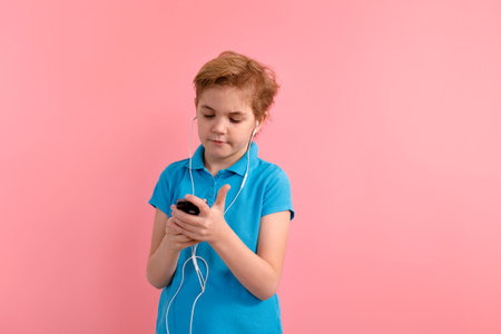 Cheerful cute boy chatting by mobile phone on white background. Looking aside.