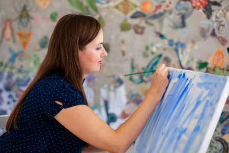 Bringing her creativity to life. Woman painting in her art studio. RUSSIA, KRASNODAR, 06/29/2014の写真素材