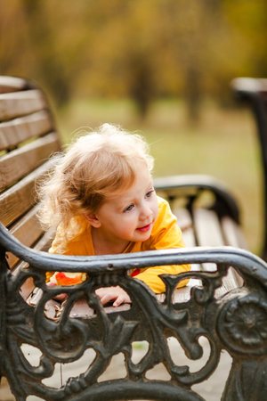Happy little girl in yellow shirt enjoying autumn nature.の写真素材