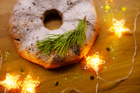 Traditional Christmas baked Stollen, glowing starry garland nearby.の写真素材