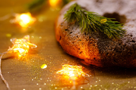 Traditional Christmas baked Stollen, glowing starry garland nearby.の写真素材