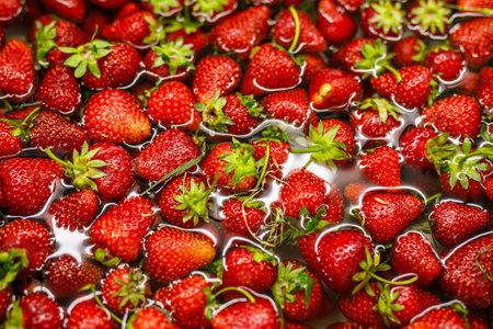 Background of ripe juicy strawberries in clear water.の写真素材