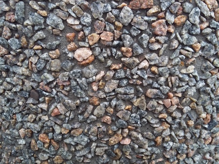small pebbles frozen in cement on construction site gray backgroundの写真素材