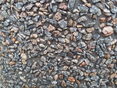 small pebbles frozen in cement on construction site gray backgroundの写真素材