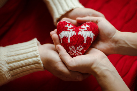 Top view picture of male and female hand with knitted heart.の写真素材