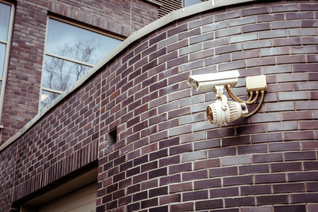 Security camera on the brick wall of building.の写真素材