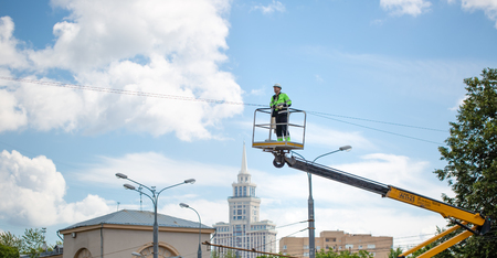 MOSCOW, RUSSIAN FEDERATION - JULY 06, 2018:  Electrician raising in bucket, prepare to repairing high voltage system.のeditorial素材