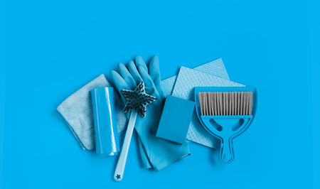 Blue set for spring cleaning in the house - rags, rubber gloves, sponges, brush and a scoop with a broom. Top view. Place for text.の写真素材