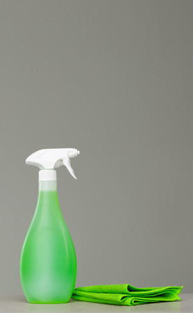 Cleaning green spray bottle with plastic dispenser and cloth for dust.の写真素材