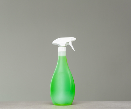 Green bottle of cleaning agent in spray on grey background.の写真素材