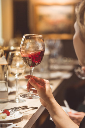 Sommelier spins the wine in a glass to assess its qualities.