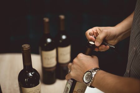 St. Petersburg, Russian Federation-August 16, 2018: man uncorks a bottles of wine. Prepares wine for sommeliers training.のeditorial素材