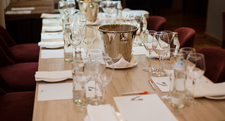 Wine tasting: table served wiht tasting lists, glasses, bottles with water and spittoon.の写真素材
