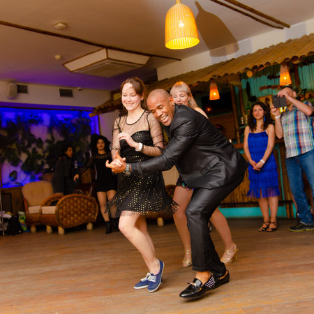 Moscow, Russia-January 19, 2019: Cuban man dancing salsa with two girls at the club.