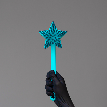 A hand in a rubber glove holds the dishwashing brush on a neutral background. The concept of bright spring, spring cleaning.の写真素材