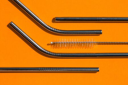 Tubes from environmental reusable metal. Horizontal. Copy space. Flat lay, orange background,top view. Concept zero waste.の写真素材