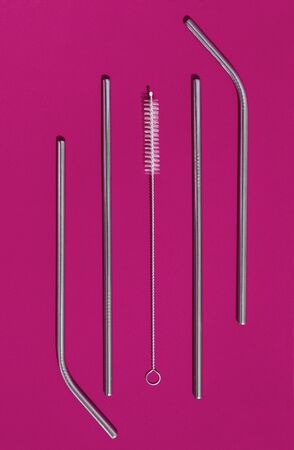 Ecological reusable tubules for drinking. Zero waste concept. Metal tube for drinking and brush for cleaning on fuchsia background.の写真素材