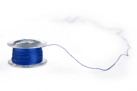 sewing machine spool with blue thread on it close upの写真素材