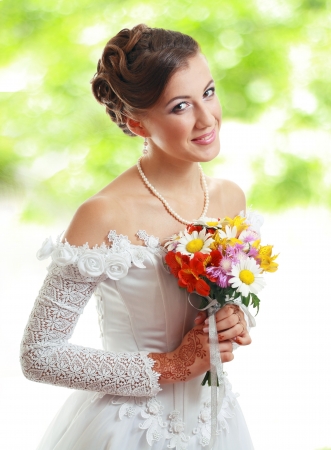 Beautiful young bride in white dress and pearl necklace outdoor with nice blur backgroundの写真素材