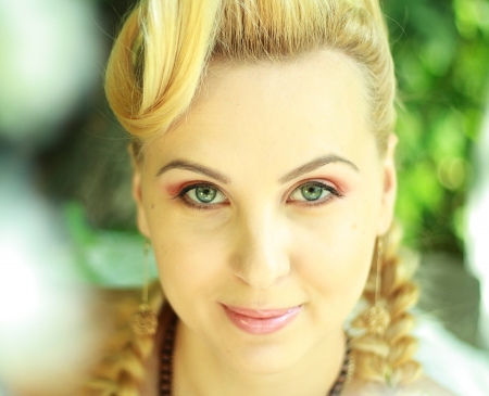 Romantic young woman face close up outdoors at a summer day. Soft summer colors.の写真素材