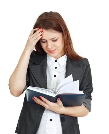 beautiful woman tired with office work trying to concetrate holding notebook and penの写真素材
