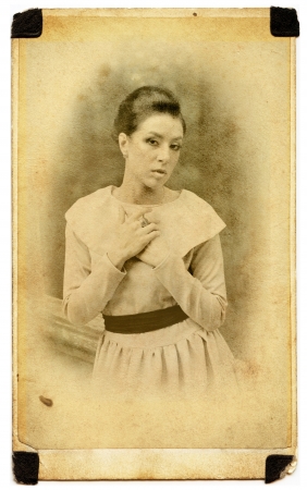 thoughtful Young lady weared in old fashion dress outdoor in old photo cardの写真素材