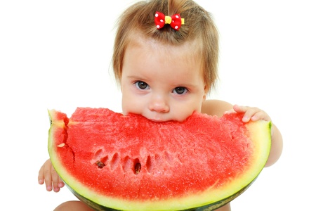 cute little baby girl eating watermelon slice on white backgroundの写真素材