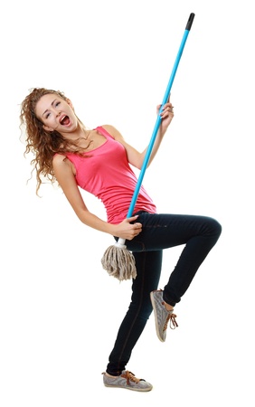 Beautiful woman having fun by playing air guitar with the mop. Isolated on white background.の写真素材