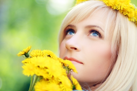 Closeup portrait of pretty young lady with yellow flowers in a park - Outdoorの写真素材