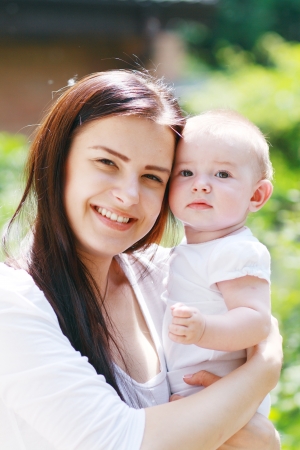 Mother with baby at outdoors in green parkの写真素材