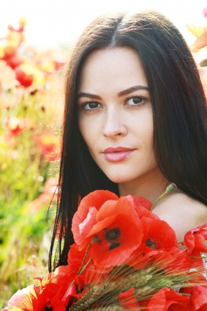 Series. Young girl with long hair in poppies field soft summer colorsの写真素材
