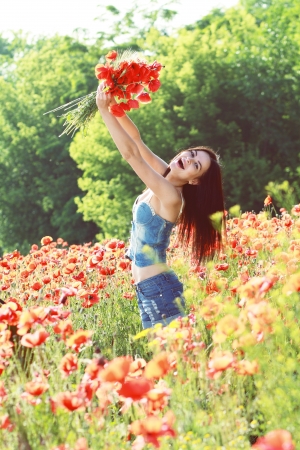 Series. Young girl with long hair in poppies field soft summer colorsの写真素材