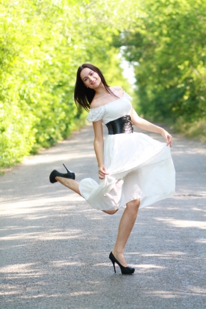 The woman dancing on road in sunny dayの写真素材