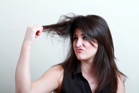 Charming brunette is not happy with fragile hairの写真素材