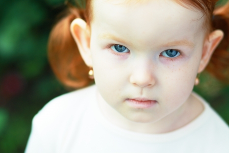 Portrait of a sad curly little girlの写真素材