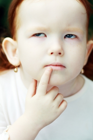 Portrait of a thoughtful cute little girlの写真素材