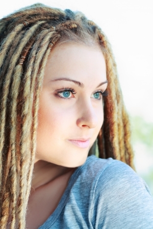 Beautiful young woman with dreadlocks being playfulの写真素材
