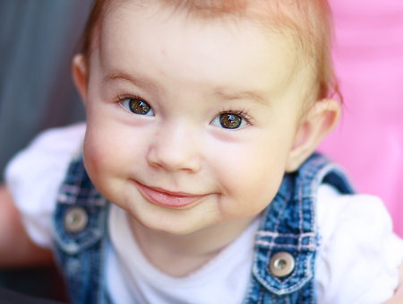 Beautiful baby few months old with charming smile outdoors