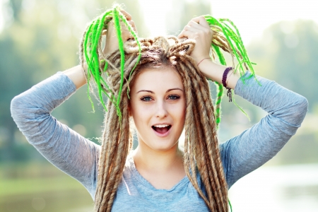 Beautiful young woman with dreadlocks being playfulの写真素材