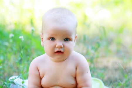 Portrait of calm baby girl on natural background in summerの写真素材